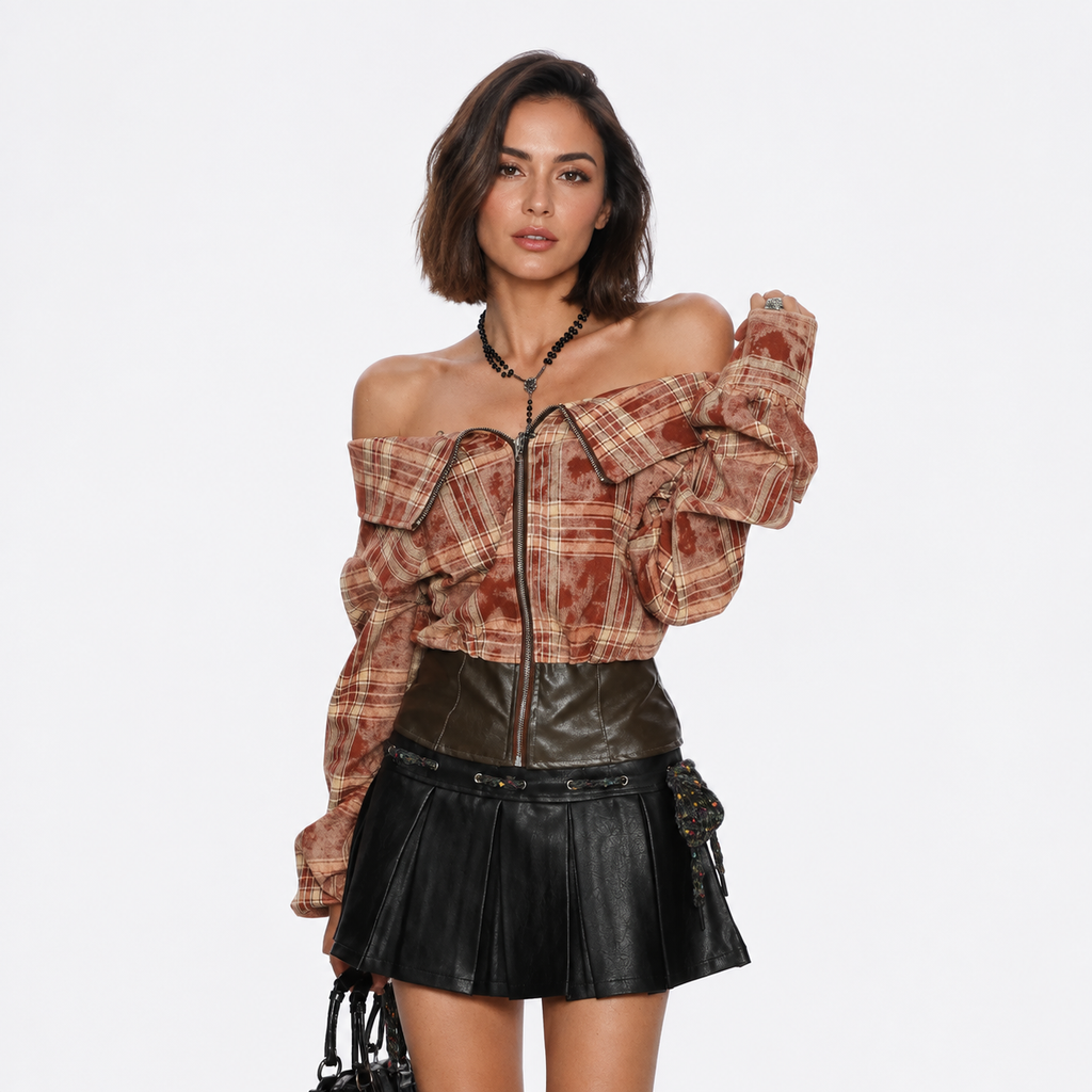 A model wearing a brown and beige plaid off-the-shoulder zip-up jacket with dramatic puffed sleeves, paired with a black faux-leather mini skirt and a black beaded necklace, against a plain white background.