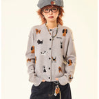 Adorable grey knit cardigan featuring a charming puppy print design. This cropped style offers a playful, contemporary look perfect for casual outings or layering. Crafted from soft, comfortable knit fabric that moves with you throughout the day. The cropped length pairs effortlessly with high-waisted bottoms for a modern silhouette. Ideal for animal lovers seeking a cozy yet stylish piece to add to their wardrobe.