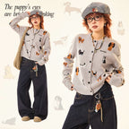 Adorable grey knit cardigan featuring a charming puppy print design. This cropped style offers a playful, contemporary look perfect for casual outings or layering. Crafted from soft, comfortable knit fabric that moves with you throughout the day. The cropped length pairs effortlessly with high-waisted bottoms for a modern silhouette. Ideal for animal lovers seeking a cozy yet stylish piece to add to their wardrobe.